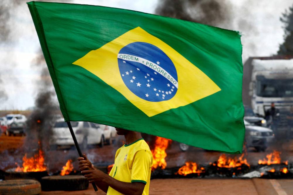 Apoiador de Jair Bolsonaro segura bandeira em bloqueio na rodovia BR-251 em Planaltina - Diego Vara/Reuters